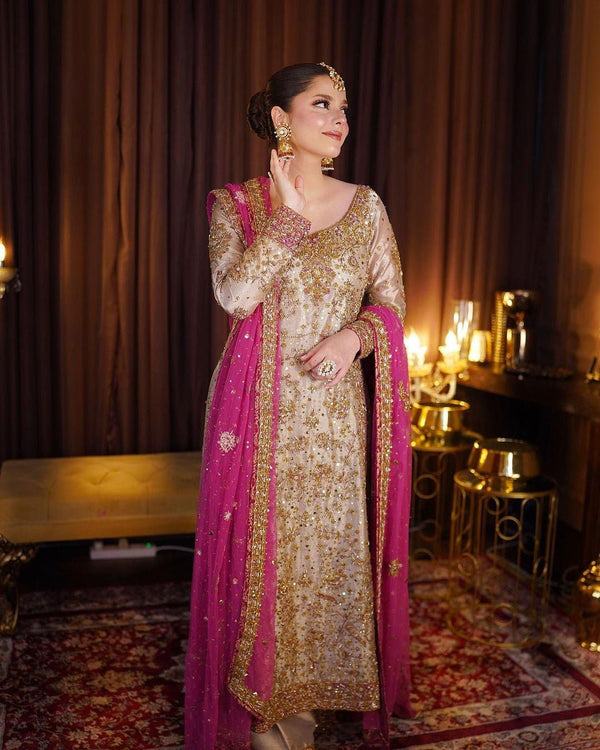 Haris Shakeel Gold & Pink pakistani indian wedding bridal dress, mehndi nikkah oufits guest suits
Product Description: Haris Shakeel embodies a white color on an net, which features intricate embroidery inspired by nature’s floral composition all over. Further layered with mesmerizing embellishments of sequins, pearls, and crystals. The outfit is paired with a modern look flared pants, and a sophisticatedly embroidered dupatta concluded with minimalistic borders, making this ensemble just the perfect choice